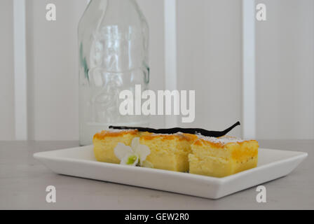 Vanille-magische Kuchen über einem weißen Teller mit Flasche im Hintergrund. Hausgemachte Desserts. Essen Stockfoto