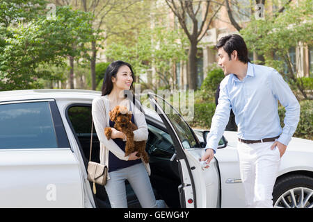 Junge chinesische paar aus Auto mit ihrem Hund Stockfoto