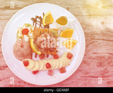 Honey Toast, bestehend aus Brot mit Honig und Eis auf Holztisch Stockfoto