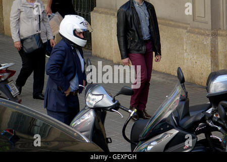 Ein Business-Mann in einem Anzug gekleidet kommt, um auf einem Motorroller zu arbeiten ist einer von Barcelonas wichtigsten Transportmittel für Stockfoto