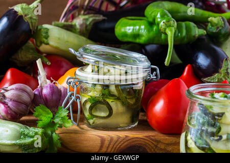 Eingemachte Zucchini und frischem Gemüse. In Scheiben geschnittenen Zucchini mit Petersilie und Knoblauch, hausgemachte Gemüse bewahrt in Glas Stockfoto