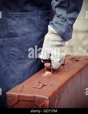 wanderte mit alten Leder Koffer und der gebrochenen Handschuh während der Reise im Ausland Stockfoto