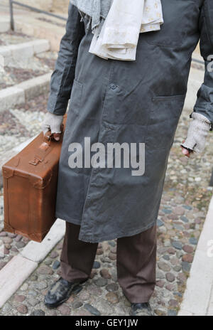 armen Einwanderer mit alten Leder Koffer und schmutzigen Kleid Stockfoto