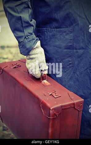 armen Einwanderer mit alten Leder Koffer und der gelöste Handschuh unterwegs Jobs im Ausland Stockfoto