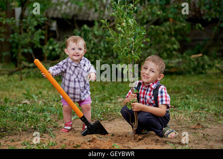 lustiger Junge mit Schaufel im Garten Stockfoto