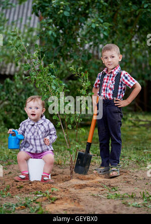 lustiger Junge mit Schaufel im Garten Stockfoto