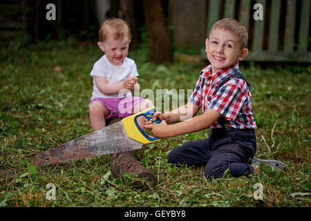 junge Sägen umgestürzten Baum im Garten Stockfoto