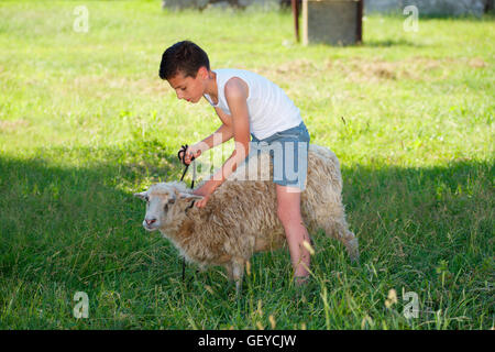Junge mit Schaf im Dorf Stockfoto