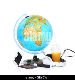 Blauer Globus, Handy, Sonnenbrille und Kopfhörer auf weißem Hintergrund. Stockfoto