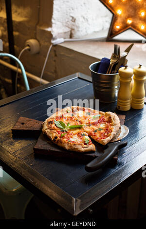 Pizza Margherita frisch gebacken auf einem Tisch im café Stockfoto