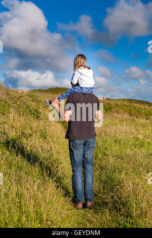 Vater und Tochter. Papa geben weibliche Kind eine Schulter-Fahrt. Papa, die kleine Mädchen tragen. Vaterschaft-Konzept. Stockfoto