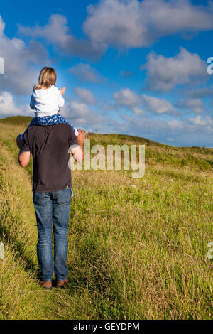 Vater und Tochter. Papa, die kleine Mädchen tragen. Papa geben weibliche Kind eine Schulter-Fahrt. Vaterschaft-Konzept Stockfoto