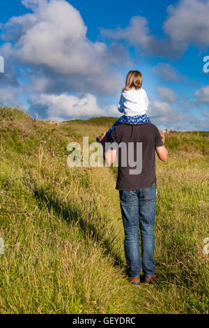 Vater und Tochter. Papa, die kleine Mädchen tragen. Papa geben weibliche Kind eine Schulter-Fahrt. Elternschaft Familienkonzept. Stockfoto