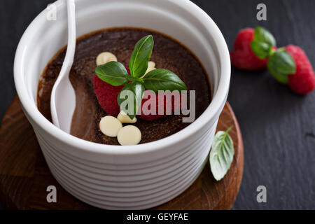 Schokoladenpudding mit Himbeeren und Basilikum Stockfoto
