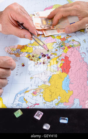 Händler in Edelsteinen machen Geschäfte auf seinem Schreibtisch. Zahlung Edelstein in Euro. Stockfoto