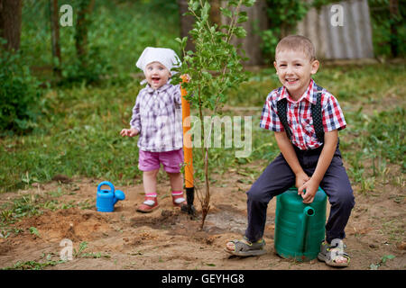 lustiger Junge mit Schaufel im Garten Stockfoto