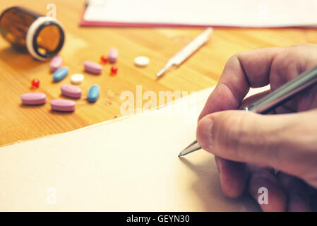 Des Arztes Hand schreiben Rezept, hautnah mit selektiven Fokus Stockfoto