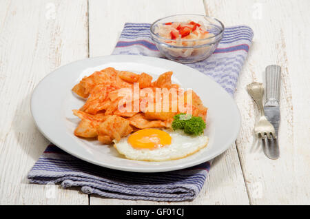 ungarische Gericht mit Paprika, Kartoffeln, Nudeln und Spiegelei auf einem weißen Teller Stockfoto