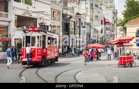 Istanbul, Türkei - 1. Juli 2016: Vintage rote Straßenbahn fährt auf der Istiklal Straße in Istanbul, jungen Fahrt kostenlos auf der Stoßstange Stockfoto