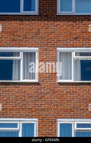 Formen und Muster von vier Fenstern in einem Wohnblock Stockfoto