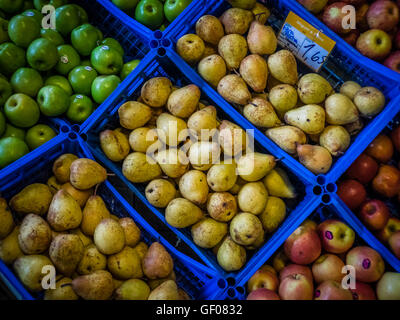 Frische gelbe Birnen und grüne und rote Äpfel zu verkaufen in blau Kunststoff-Körben auf dem lokalen Markt in Ponta Delgada, Sao Mi gespeichert Stockfoto