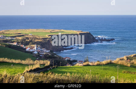 Tee-Plantage auf dem Hügel in der Nähe des kleinen Dorfes mit einem großen katholischen Kirche auf der Küste von Sao Miguel, Azoren, Portugal Stockfoto