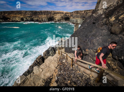 Touristen, die Wanderungen entlang der Küste in Ajuy, Parque Rural de Betancuria auf Fuerteventura, Kanarische Inseln, Spanien. Bild aufgenommen Stockfoto