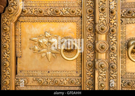 Eine vergoldete Tür und Türgriff an Chandra Mahal, eines der Schlösser in Jaipurs City Palace, Rajasthan, Indien. Stockfoto