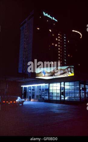 Eine Tankstelle und ein Plakat in der Nähe von Holiday Inn in Hollywood, CA, in der Nacht. Stockfoto