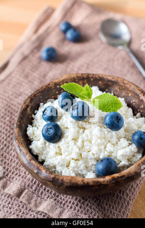 Hüttenkäse (Quark) mit frischen Heidelbeeren mit Minze dekoriert. Gesundes Frühstück Essen Stockfoto