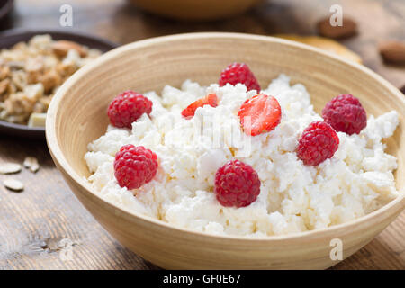 Hüttenkäse mit Joghurt, Früchten und Nüssen auf hölzernen Hintergrund, Seitenansicht, selektiven Fokus. Abnehmen, Gesundheit Stockfoto