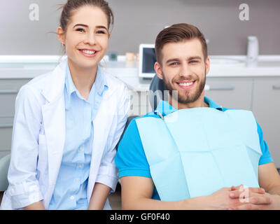 Mein Zahnarzt ist der beste! Portrait einer Zahnärztin und junger Mann in eine Zahnarztpraxis. Stockfoto