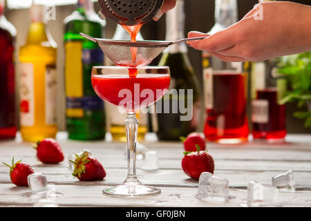 Rote Getränk gießt durch Sieb. Stockfoto