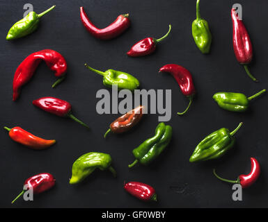 Muster von kleinen bunten hot Chili Peppers auf schwarzem Hintergrund Stockfoto