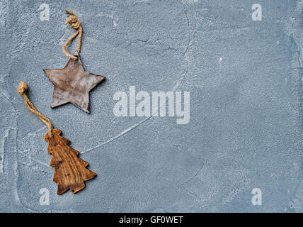 Weihnachten oder Neujahr Hintergrund. Spielzeug rustikalen hölzernen Stern und Fell Baum über Grunge graue Oberfläche, Ansicht von oben Stockfoto