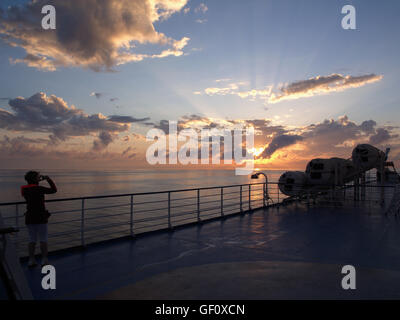 Blick auf den Sonnenuntergang vom Hauptdeck der Minoan Lines Fähren Cruise Olympia, mit Dame Passagier nehmen Foto Stockfoto