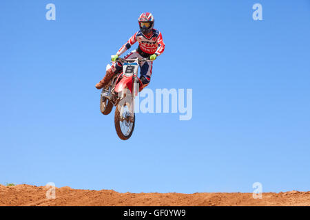 Motocross-Fahrer und Bike clearing eine Tischplatte zu springen, während die letzte Wärme des Rennens Stockfoto