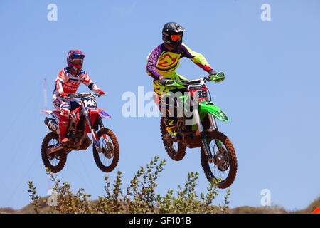 Motocross-Fahrer und Bike clearing eine Tischplatte zu springen, während die letzte Wärme des Rennens Stockfoto