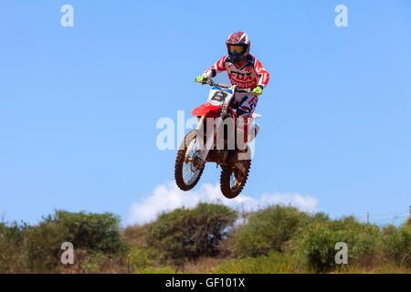 Motocross-Fahrer und Bike clearing eine Tischplatte zu springen, während die letzte Wärme des Rennens Stockfoto