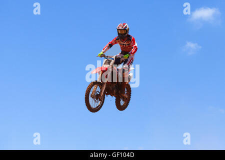 Motocross-Fahrer und Bike clearing eine Tischplatte zu springen, während die letzte Wärme des Rennens Stockfoto