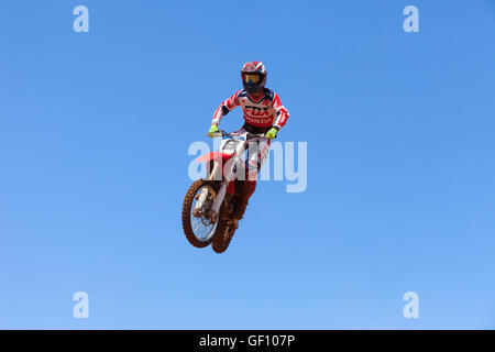 Motocross-Fahrer und Bike clearing eine Tischplatte zu springen, während die letzte Wärme des Rennens Stockfoto