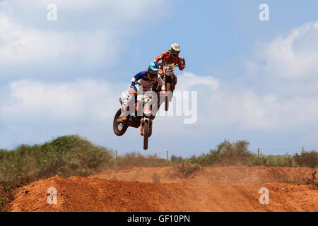 Motocross-Fahrer und Bike clearing eine Tischplatte zu springen, während die letzte Wärme des Rennens Stockfoto