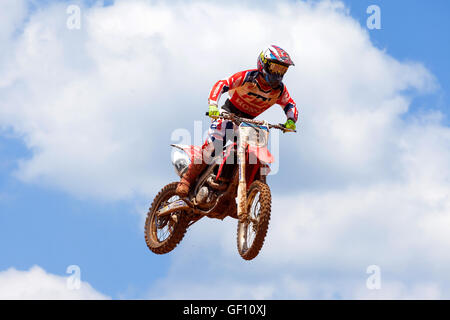 Motocross-Fahrer und Bike clearing eine Tischplatte zu springen, während die letzte Wärme des Rennens Stockfoto