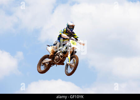 Motocross-Fahrer und Bike clearing eine Tischplatte zu springen, während die letzte Wärme des Rennens Stockfoto