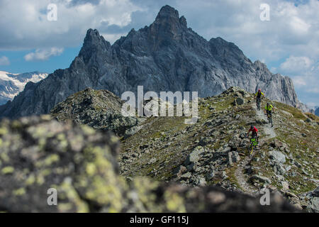 Drei Mountainbiker fahren den Grat zwischen Courchevel und Méribel Weg von der Aiguille du Fruit-Gipfel in den französischen Alpen Stockfoto