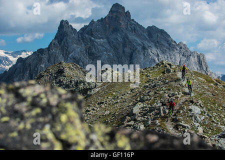 Drei Mountainbiker fahren den Grat zwischen Courchevel und Méribel Weg von der Aiguille du Fruit-Gipfel in den französischen Alpen Stockfoto