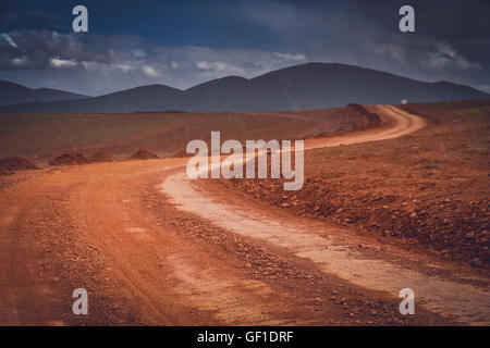 Schnee fällt im Sommer auf einer schlammigen und Lehm Bergstraße durch den zentralen tibetischen Hochplateau, Tibet, China Stockfoto