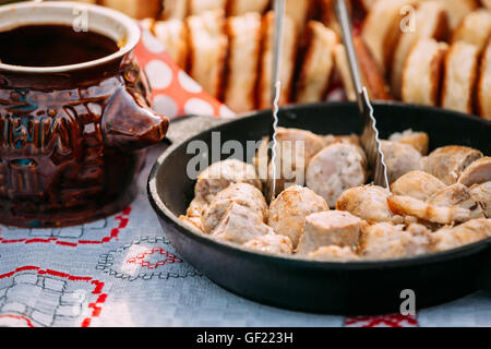 Die Gerichte der traditionellen belarussischen Küche - gebratenen Speck und Fleisch Wurst, Gebäck. Stockfoto