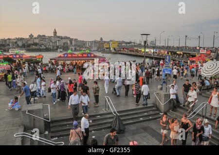 Die Menschen gehen auf das Goldene Horn Uferpromenade von Galata-Brücke in Eminönü an einem Sommerabend.  Die Geländer der Galata-Brücke können Stockfoto