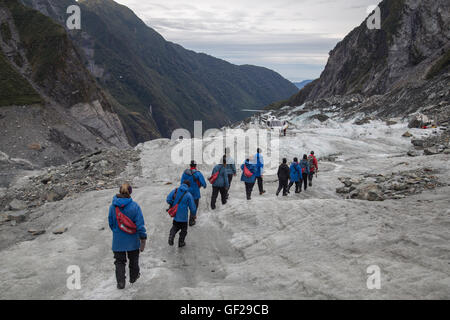 Franz Josef, New Zealand - 22. März 2015: eine Gruppe von Touristen Wandern in Richtung eines Hubschraubers auf der Franz Josef Glacier. Stockfoto